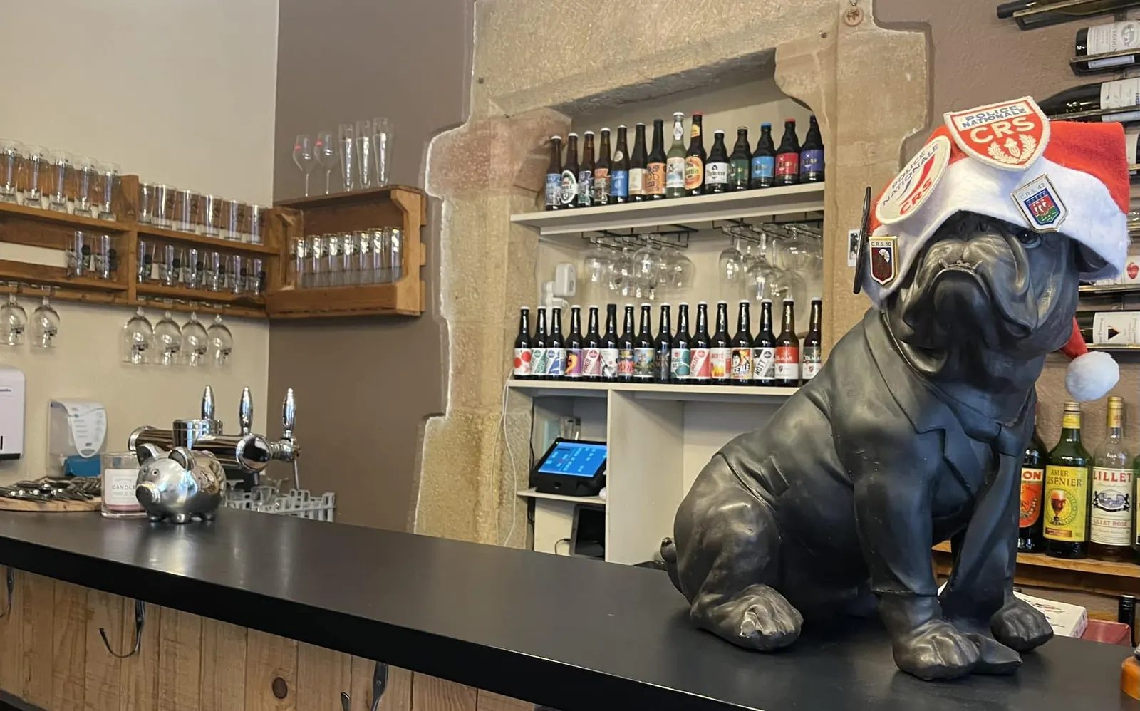 Le comptoir : bières dans la niche en pierre, tireuses et bouledogue en costume