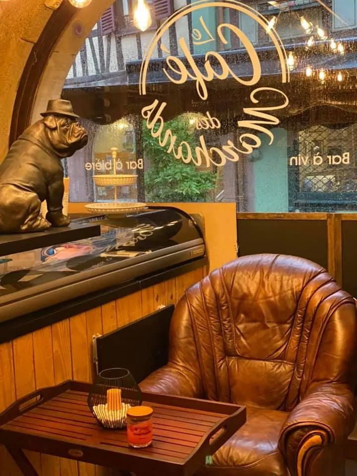 Fauteuil Chesterfield et bouledogue devant la vitrine au logo